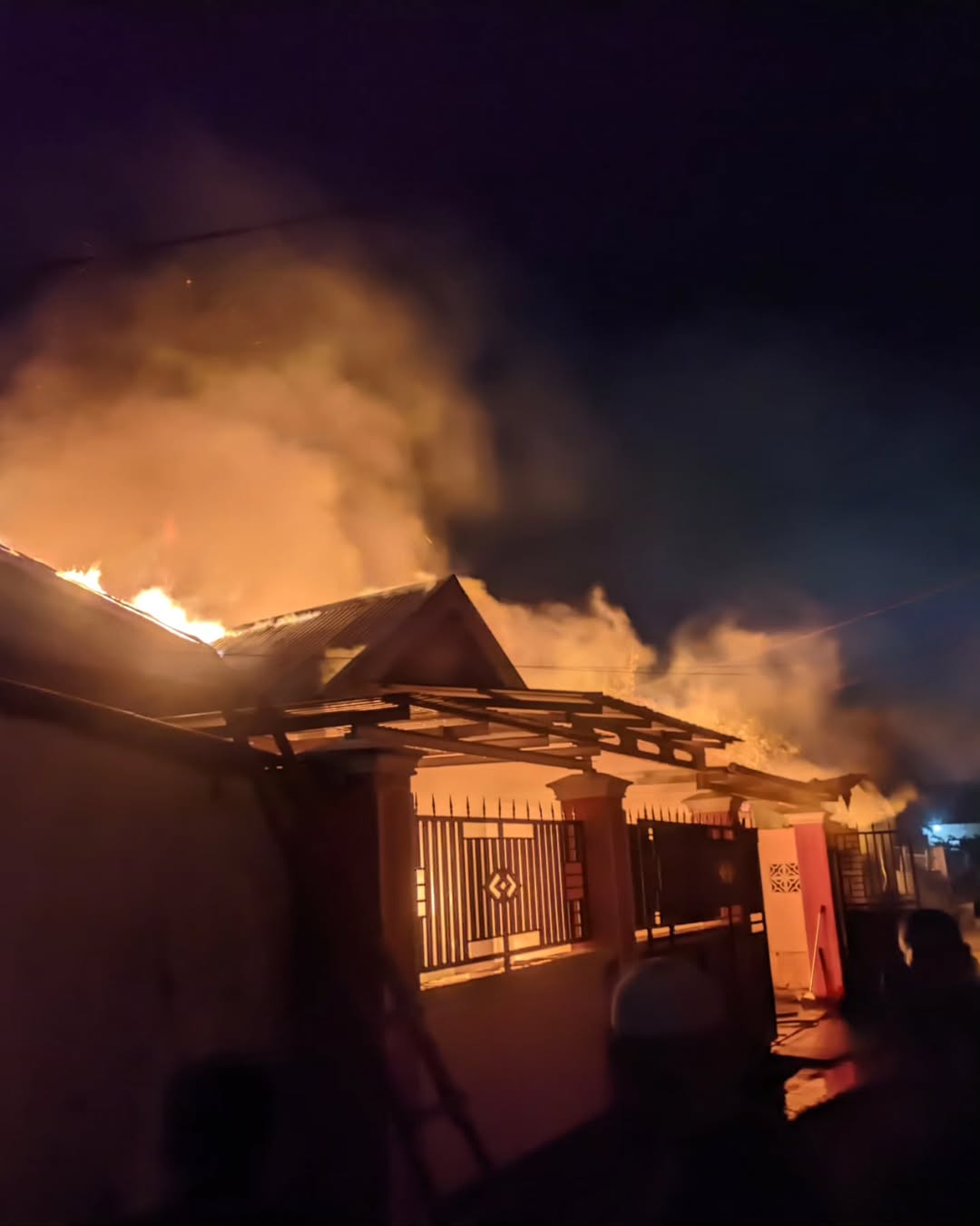 Foto: Api terlihat melahap bagian atap salah satu rumah. (damkarmat kota palu)